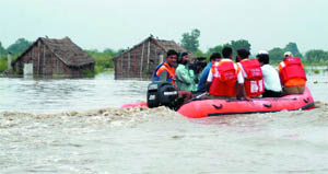 A rescue team at work in the flooded slum area near the river.