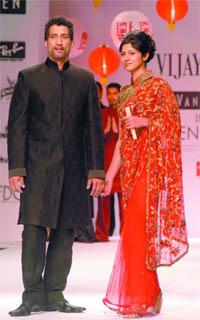 Cricketer Atul Vasan and his wife display creations by Vijay Arora during the Van Huesen India Men's Fashion Week in New Delhi on Saturday.