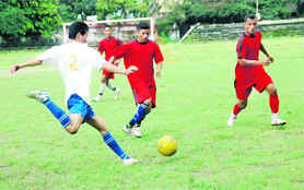 Players vie for the ball at the Dehradun Football League in Dehradun on Saturday.