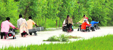 Villagers wade through water in Chandrao village.