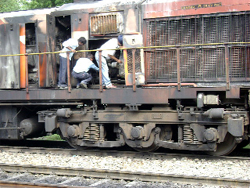 Railway officials examining the rail engine that caught fire near Lehra Mohabbat railway station on Sunday.