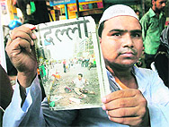 Shakeel Ahmed, who was injured in a blast at Barakhamba road on September 13, 2008, holds a newspaper showing his picture at the blast site, during a Shradhanjali Sabha organised by the All-India Anti-Terrorist Front at Beadonpura in Gaffar Market, New Delhi.