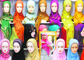A woman tries a headscarf at a market in Makassar, South Sulawesi, on Sunday.