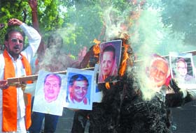 Shiv Sena activists burn pictures of UPA chairperson Sonia Gandhi and some union ministers during a protest against the rising prices of basic commodities in New Delhi