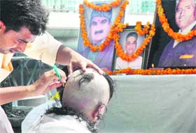 A displaced Kashmiri Pandit gets his head tonsured at a protest to mark the 20th Kashmiri Pandit Martyrs Day in New Delhi