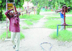Workers dismantle swings at Children Park in Ram Bagh in Amritsar.Photo: Vishal Kumar