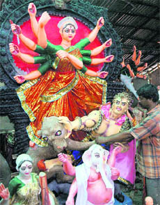 An artist gives final touches to an idol of Goddess Durga at Kali Bari Temple in Sector 31, Chandigarh, on Wednesday.