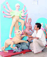 An artiste prepares idols for Durga Puja in Dehradun on Wednesday.