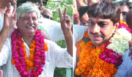 RJD candidate Asif Mohammed Khan (Left) and BJP candidate Parduymn Rajput celebrate their victories from Okhla and Dwarka seats, respectively, in New Delhi on Thursday.