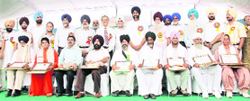 Manpreet Badal with the farmers, who were honoured during the opening day of Kisan Mela on Thursday.