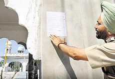Initiating the process of declaring Baba Prithpal Singh a proclaimed offender, an official of the Chandigarh police puts a document outside his house at Gurdwara Gur Sagar Sahib near Sukhna Lake in Chandigarh on Friday.