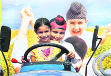 Children strike a pose on a fancy tractor displayed at Kisan Mela at Punjab Agricultural University in Ludhiana on Friday.