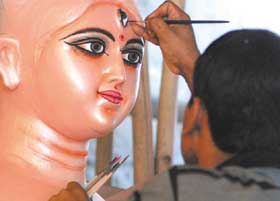 An artist prepares an idol of Godess Durga at Shahdara Kali Mandi in New Delhi on Sunday. 
