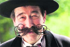 A participant of the international World Beard and Moustache Championship smiles in Gruendau, near Frankfurt