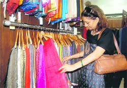 A woman has a look at the saris displayed at the Fab-India exbihition in Dehradun on Monday