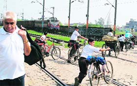Even as a train approaches, these schoolchildren hurry up to cross the rail track at Ambala City, putting their lives to great risk