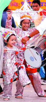 Young children wearing fancy clothes dance on the beats of dhol at the Durgiana Temple complex in Amritsar. 