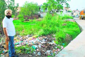Rajwinder Singh of Desu Majra village, Kharar, points towards the controversial piece of land