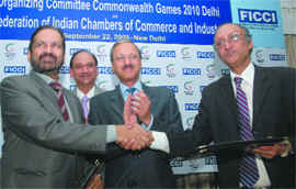 Indian Olympic Association president and chairman of Commonwealth Games Organising Committee Suresh Kalmadi (L) with FICCI secretary general Amit Mishra (R) after signing an MoU in New Delhi on Tuesday. 