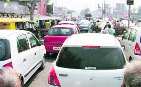 Vehicles caught in a traffic jam caused by non-functional traffic lights due to frequent power cuts at Bharat Nagar Chowk, Ludhiana, on Tuesday.