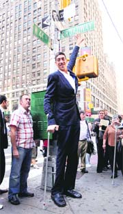 The worlds tallest man, Sultan Kosen of Turkey, touches a street sign at Times Square, New York, on Monday. He has been verified by the GuinnessBook of World Records as the worlds tallestliving man at 8 feet 1 inch.