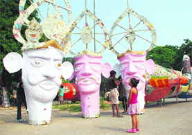 A girl takes a look at the effigies of Ravana, Kumbhkarana and Meghnath at Sector 37 in Chandigarh on Wednesday.