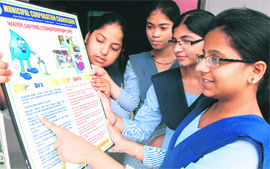 Students go through a poster on Save Water at a school in Chandigarh on Wednesday. 