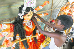 An artisan gives finishing touch to an idol of Goddess Durga in Ludhiana.