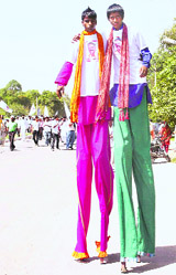 Campaigners of an Independent from Gurgaon walk on stilts. 
