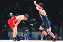 Ramesh Kumar (R) celebrates after defeating Moldovas Alexandr Burca in their mens 74 kg free style bronze medal match on Wednesday.