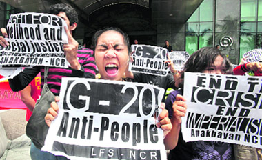 Protesters shout slogans as they picket outside the building housing the IMF-World Bank at suburban Mandaluyong city in Philippines on Thursday to protest