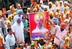 Activists of the Bhagat SIngh Youth Front along with students of a school celebrate the 102nd birth anniversary of Shaheed Bhagat Singh in Amritsar. 