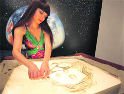Kseniya Simonova, winner of TV show contest Ukraine's Got Talent, creates a drawing in sand on Thursday.