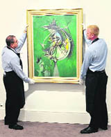 Sotheby employees hold a painting entitled Thorn Head by artist Graham Sutherland at Sotheby auction house in London.