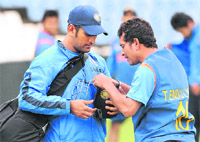 Fitting It Right: Mahendra Singh Dhoni (L) checks Sachin Tendulkars helmet during a training session in Centurion 