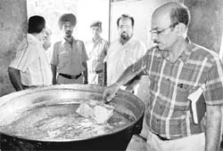 A doctor, along with officials of the heath department, takes samples of sweets from a shop at Daria village
