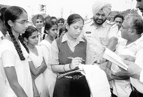 Schoolchildren challan a traffic violator during a traffic awareness programme at Phase VII, lights point, Mohali, on Saturday.
