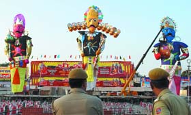 Delhi police keep watch on the effigies of Ravan, Meghanad and Kumbakaran at Subhash Maidan in New Delhi