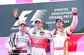 Lewis Hamilton (C),Timo Glock of Germany (L) Fernando Alonso celebrate on the podium