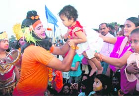 IN SAFE HANDS: An artiste dressed as Lord Ram holds a child ahead of the Dasehra celebrations at Sector 17, Chandigarh