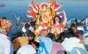 Devotees immerse an idol of Goddess Durga in the Yamuna.