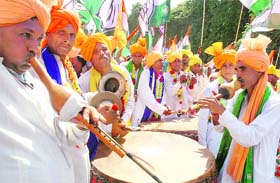 Folk artistes play their instruments as Congress nominee from Badshahpur Rao Dharampal goes to file his nomination papers in Gurgaon