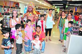 Children enjoy the company of an artiste dressed as Hanuman at a retail store in Gurgaon