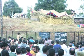 Villagers look on as the work to exhume the bodies of Shopian victims is undertaken by the CBI team at Shopian on Monday. 