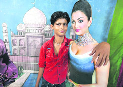 A boy gets a picture clicked with a cutout of Bollywood actor Aishwarya Rai during Dasehra fair in Ludhiana. T