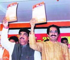Gopinath Munde of the BJP and Shiv Senas Uddhav Thackeray unveil the joint election manifesto at a press conference in Mumbai on Monday.