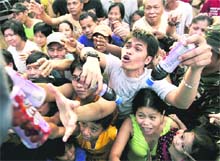 Residents scramble to receive relief goods in suburban Marikina city, east of Manila, Philippines, on Monday.