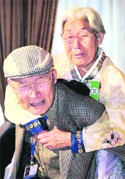 South Korean Yang Yun-hak (left) gives his North Korean elder sister a piggyback after the reunion meeting, on the Diamond Mountain in North Korea on Monday. Hundreds of family members separated for half a century by the Korean War bade tearful farewell to each other on Monday after briefly reuniting under a programme resumed amid warming ties between the North and South.