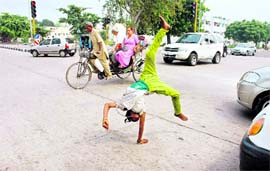 A beggar does a jig at the Sector 32-31 traffic lights.