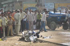 People gather at the spot where a man named Subhash died after his bike was hit by a dumper in Faridabad